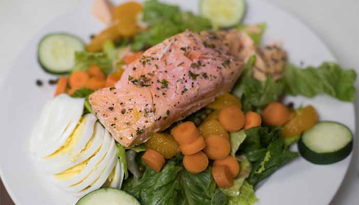 Salmon fillet over Cadence Clubhouse salad (lettuce, egg, carrots, oranges, cucumber).