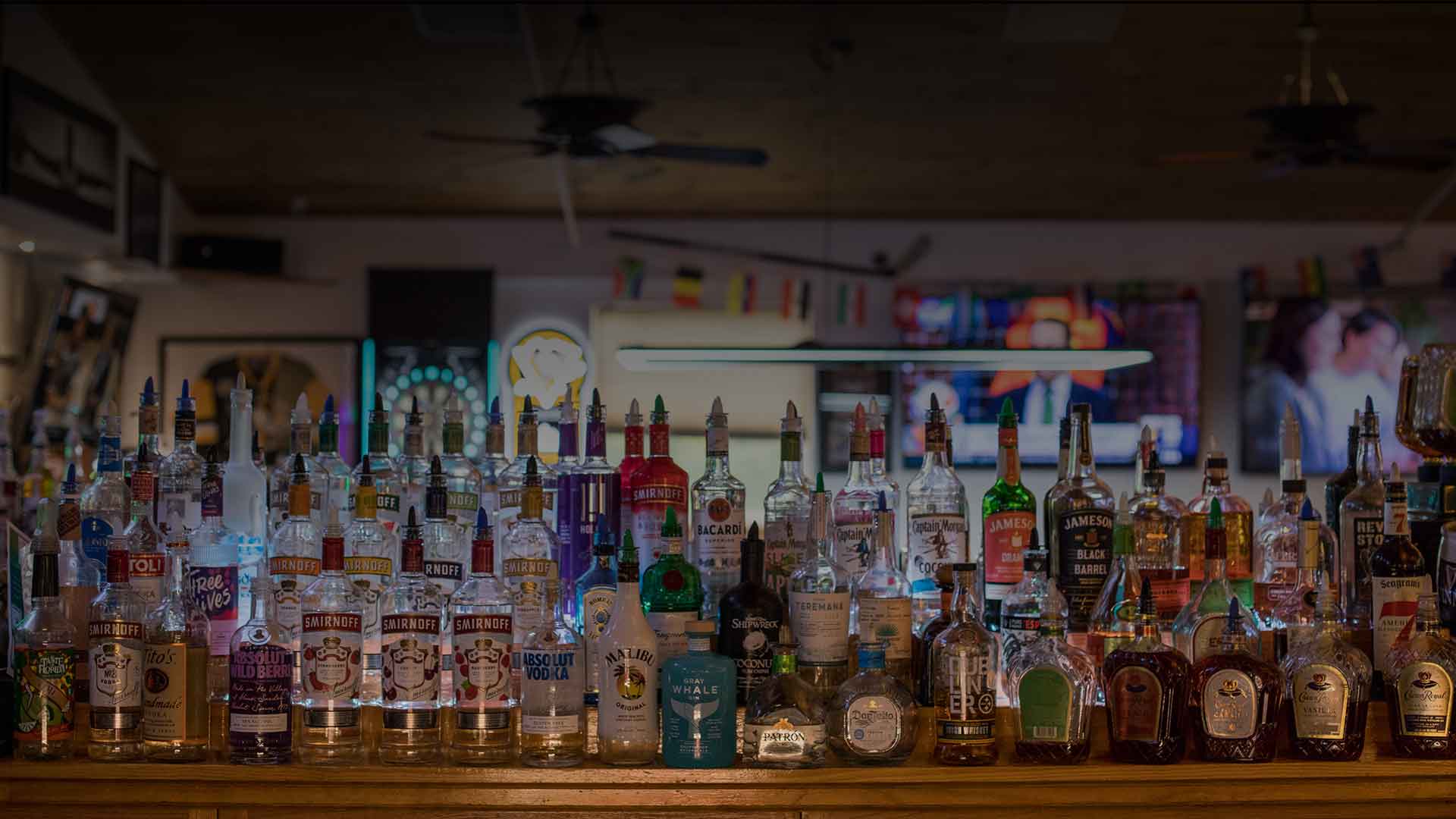 A wide array of liquor bottles lined up on a bar counter.